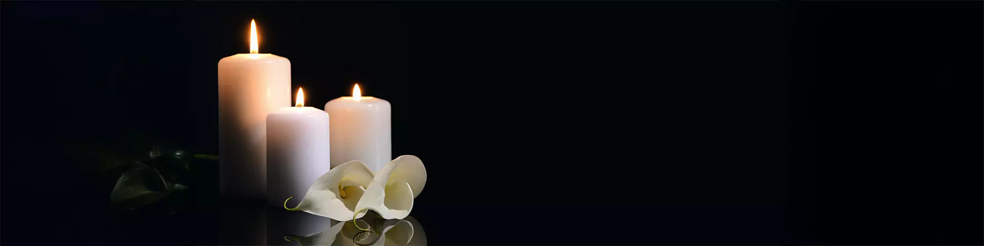 Brennende Kerzen und Blumen Brennende Kerzen und Blumen vor dunklem Hintergrund
